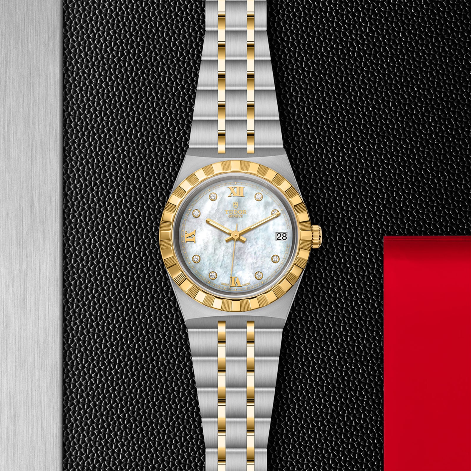 The TUDOR Royal two-tone wristwatch, featuring a stainless steel and gold band, white dial, gold Roman numerals, and diamond hour markers, is showcased against a textured black and red backdrop.