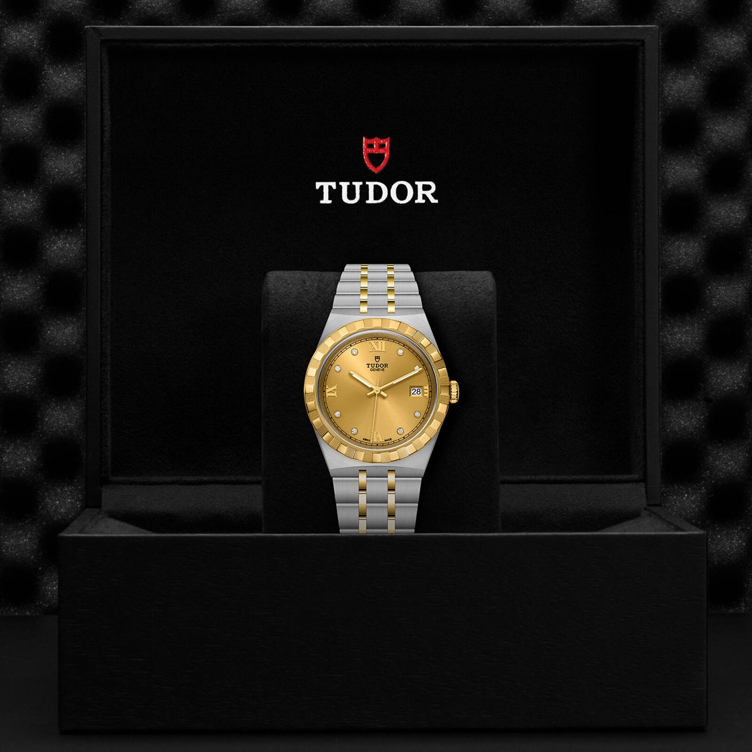 A TUDOR Royal wristwatch with a gold dial and two-tone stainless steel and gold bracelet, presented in an open black Tudor box—the Royal by TUDOR exemplifies automatic sport-chic style.