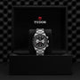 A TUDOR Black Bay Chrono wristwatch is showcased upright in an open black presentation box with the TUDOR logo, highlighting the distinguished style of this chronograph.
