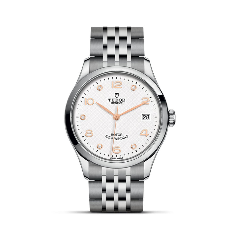 The TUDOR 1926 is a silver wristwatch with a white textured dial, gold hands and markers, date at 3 o’clock, and stainless steel bracelet—a timeless pick for mechanical watch enthusiasts.