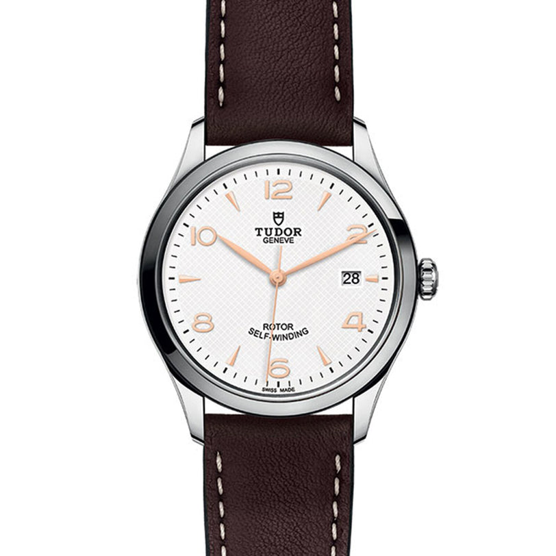 The TUDOR 1926 is a classic, elegant wristwatch featuring a white dial, brown leather strap, silver case, gold hour markers, and a date display at 3 o’clock—an ideal choice for mechanical watch enthusiasts. Marked ROTOR SELF-WINDING.