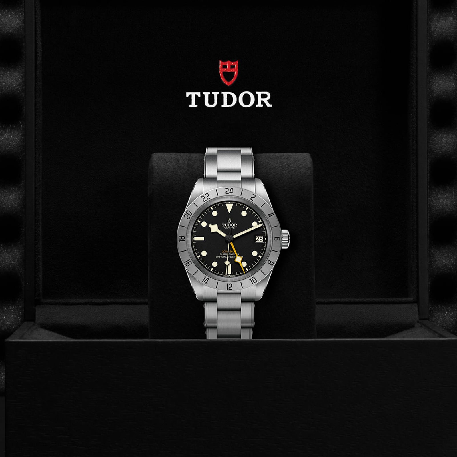 A TUDOR Black Bay Pro wristwatch displayed in an open black box with the TUDOR logo above it.