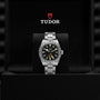 A TUDOR Black Bay Pro wristwatch displayed in an open black box with the TUDOR logo above it.