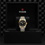 A TUDOR Black Bay One 36 S&G wristwatch with a black and gold band displayed in an open black TUDOR box.