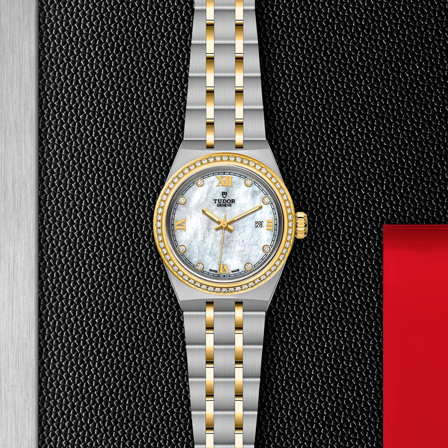 A two-tone TUDOR Royal wristwatch with a silver and gold bracelet, diamond hour markers, mother-of-pearl dial, and a gold bezel is displayed on a textured black and red background.