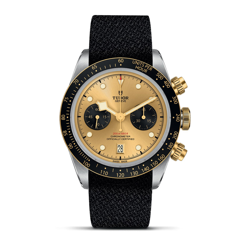 The TUDOR Black Bay Chrono S&G features a gold and black dial, black bezel, gold subdials and pushers, plus a black fabric strap, showing 10:08:37 and the date as 28—a striking example of TUDOR watches.