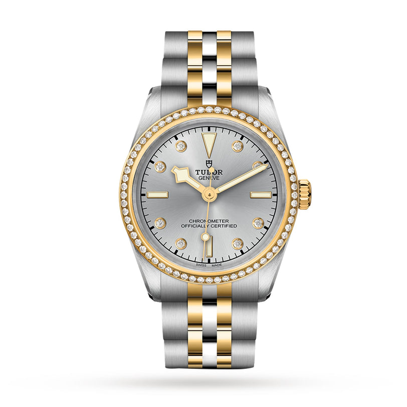 A TUDOR Black Bay One 31 S&G wristwatch with a silver dial, yellow gold markers, diamond bezel, and a stainless steel and gold bracelet is displayed on a white background.