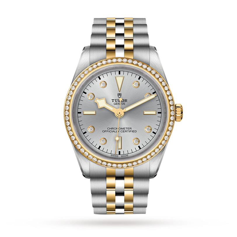 The TUDOR Black Bay One 36 S&G is a two-tone wristwatch featuring a silver dial, yellow gold accents, diamond hour markers, and a diamond-set bezel on a metal bracelet.