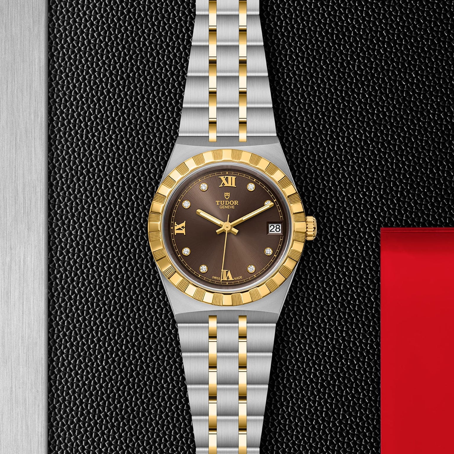 A TUDOR Royal watch featuring a gold and silver metal band, gold bezel, brown dial with date display, automatic movement, and diamond hour markers is displayed on a textured black surface for a sporty chic look.