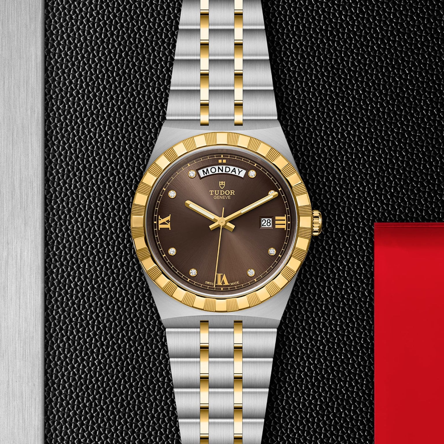 The TUDOR Royal is a sporty chic wristwatch featuring a gold and silver band, black dial with gold bezel, Roman numerals, diamond markers, automatic movement, and day-date displays on a textured black surface.