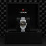 A TUDOR Black Bay 31 unisex watch with a metal band is showcased upright in an open black presentation box featuring the TUDOR logo inside the lid, highlighting the refined elegance of Black Bay models.