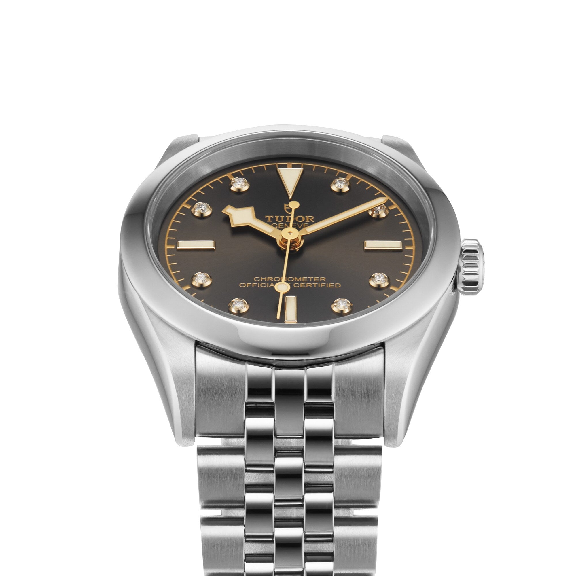 The TUDOR Black Bay 31, a stainless steel wristwatch with a black dial, gold markers, and a silver link bracelet, is shown against a white background—an effortlessly chic unisex watch powered by Manufacture Calibres.