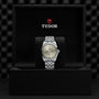 A TUDOR Black Bay One 36 wristwatch with a silver dial and 316L steel bracelet is displayed upright in a black TUDOR box, reflecting the refined craftsmanship of Black Bay models.