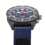 A close-up of a TUDOR Pelagos FXD Chrono wristwatch featuring a blue fabric strap and a black bezel.