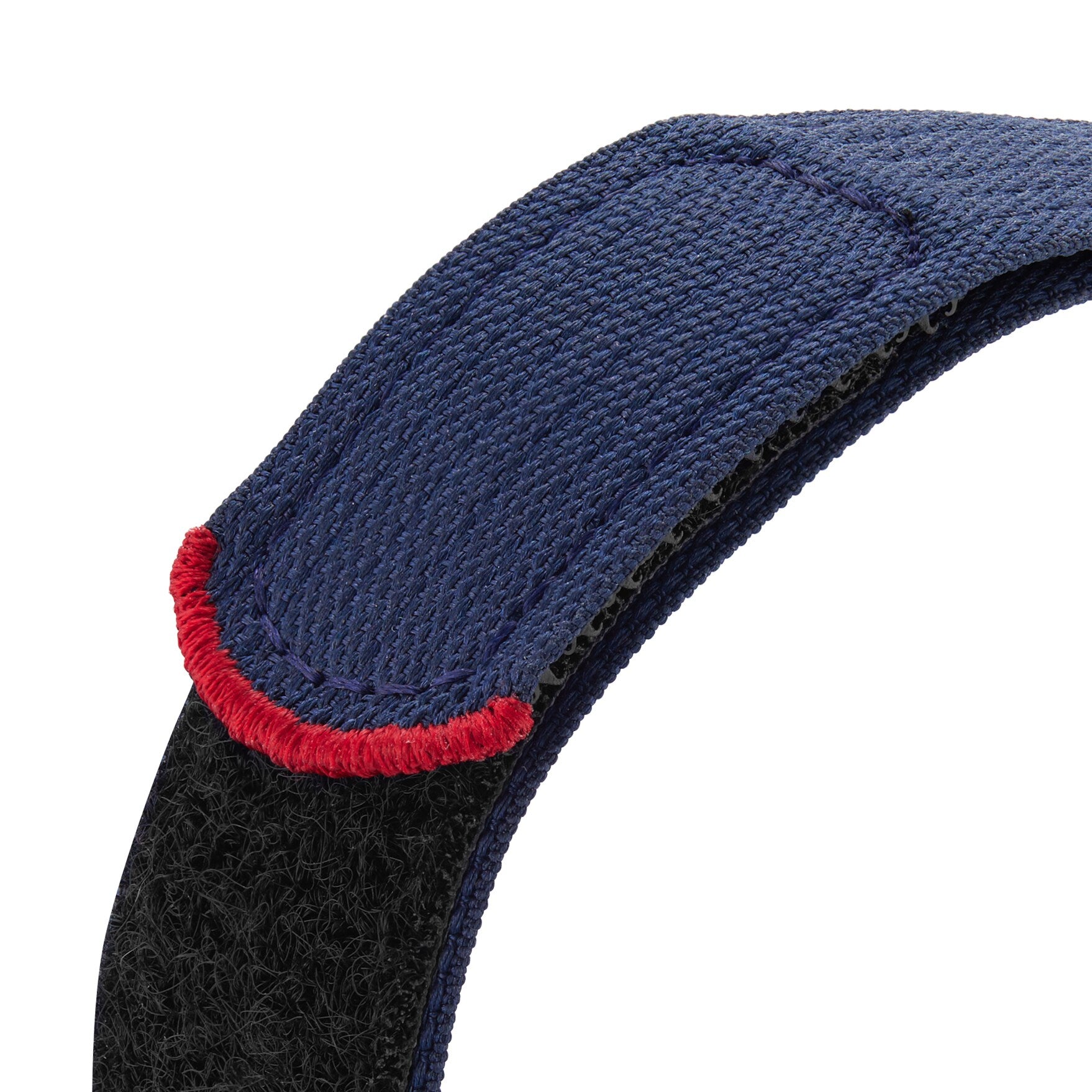 A close-up of a blue fabric strap with hook-and-loop fastener and red edge stitching, inspired by the TUDOR Pelagos FXD Chrono and its heritage in French Navy underwater navigation.