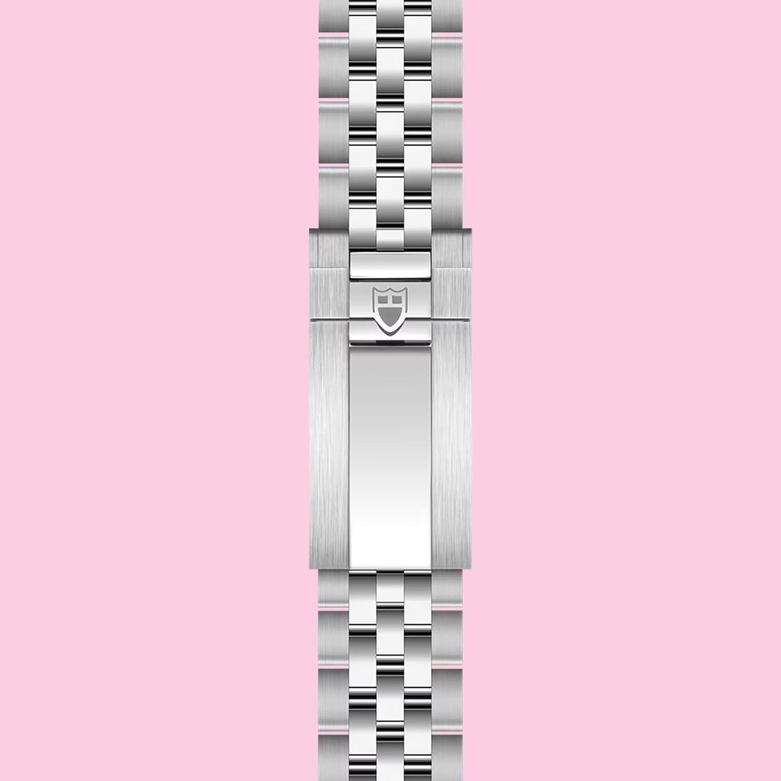 A stainless steel TUDOR bracelet with a polished clasp and embossed shield logo, shown vertically on a light pink background—ideal for pairing with the TUDOR Black Bay Chrono or any Swiss chronometer-certified watch.