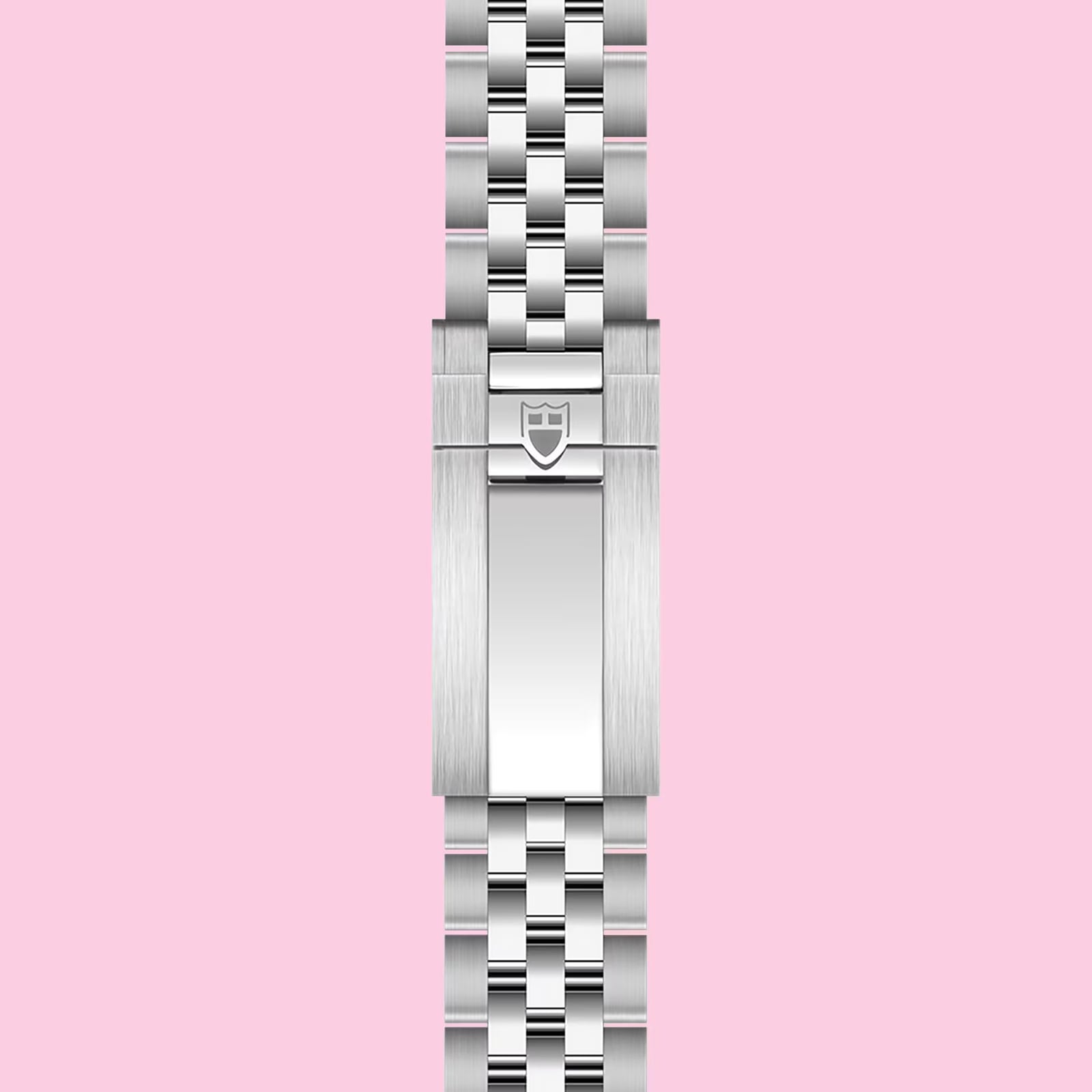 A stainless steel TUDOR bracelet with a polished clasp and embossed shield logo, shown vertically on a light pink background—ideal for pairing with the TUDOR Black Bay Chrono or any Swiss chronometer-certified watch.