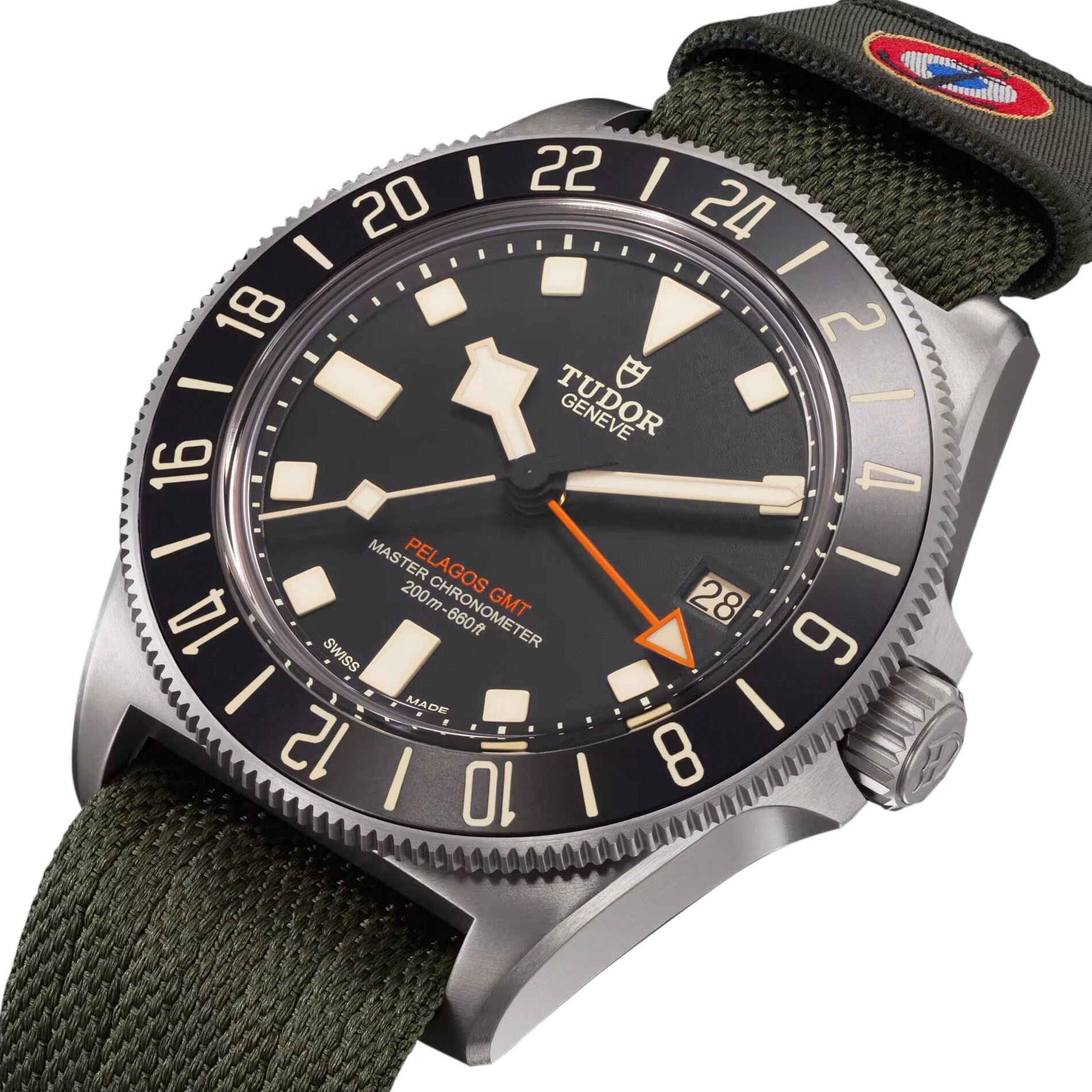 A TUDOR Pelagos FXD GMT watch featuring a black dial, rotatable bezel, and green fabric strap.