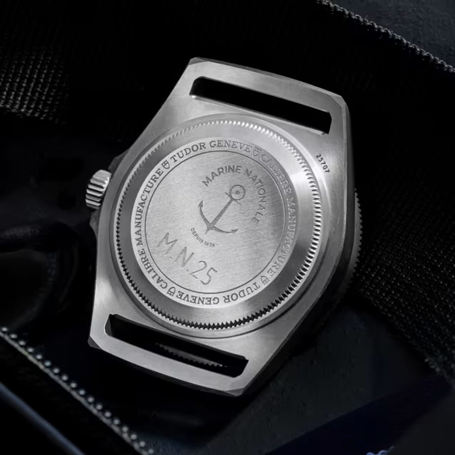 Close-up of the titanium case back on the TUDOR Pelagos FXD, engraved with Marine Nationale, an anchor emblem, M.N.25, and manufacturer details; water resistant to 200m.
