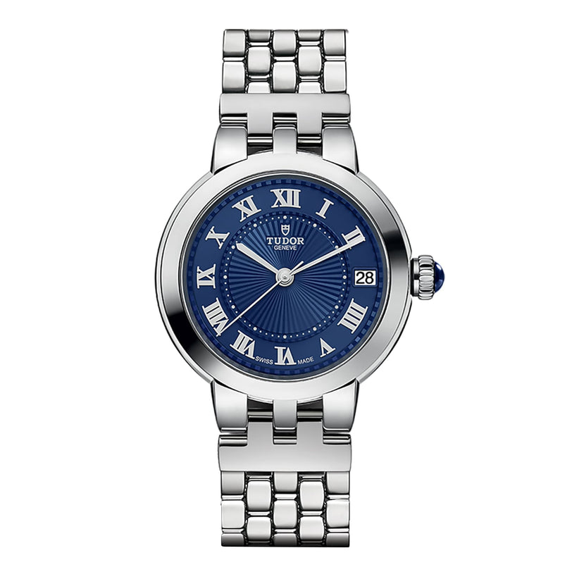 The TUDOR Clair de Rose wristwatch features a silver metal link bracelet, blue dial with Roman numerals, and a date window at 3 o’clock.
