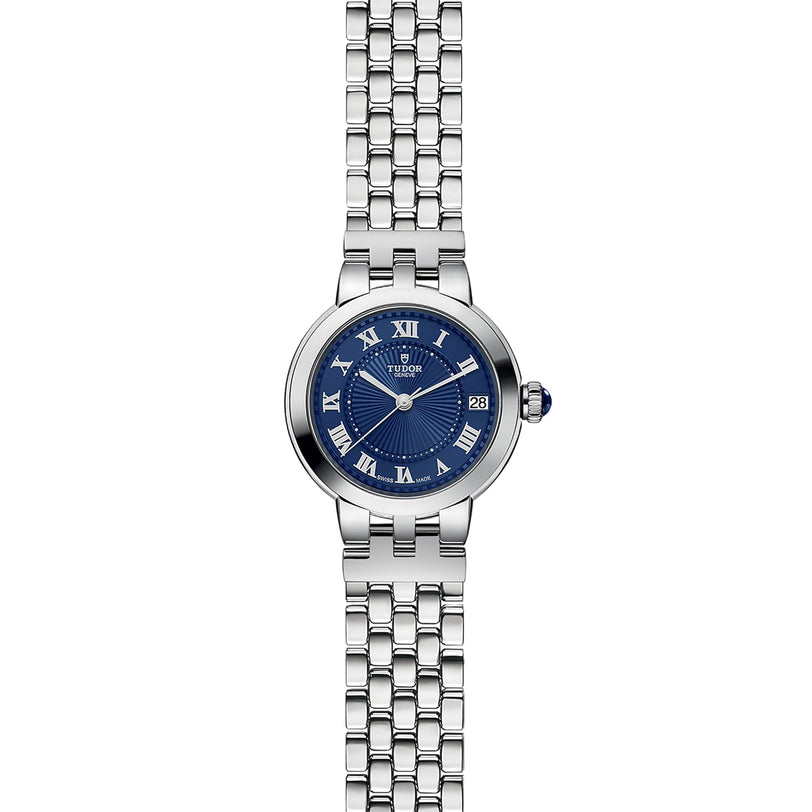The TUDOR Clair de Rose features a silver metal link band, blue face with Roman numerals, and date display.