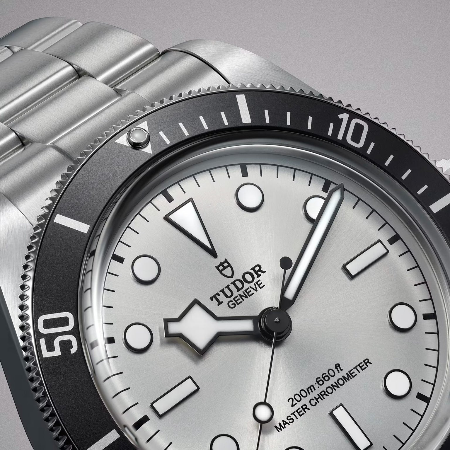 Close-up of a TUDOR Black Bay 68 dive watch featuring a silver dial, black bezel, and displaying the time 4:39.