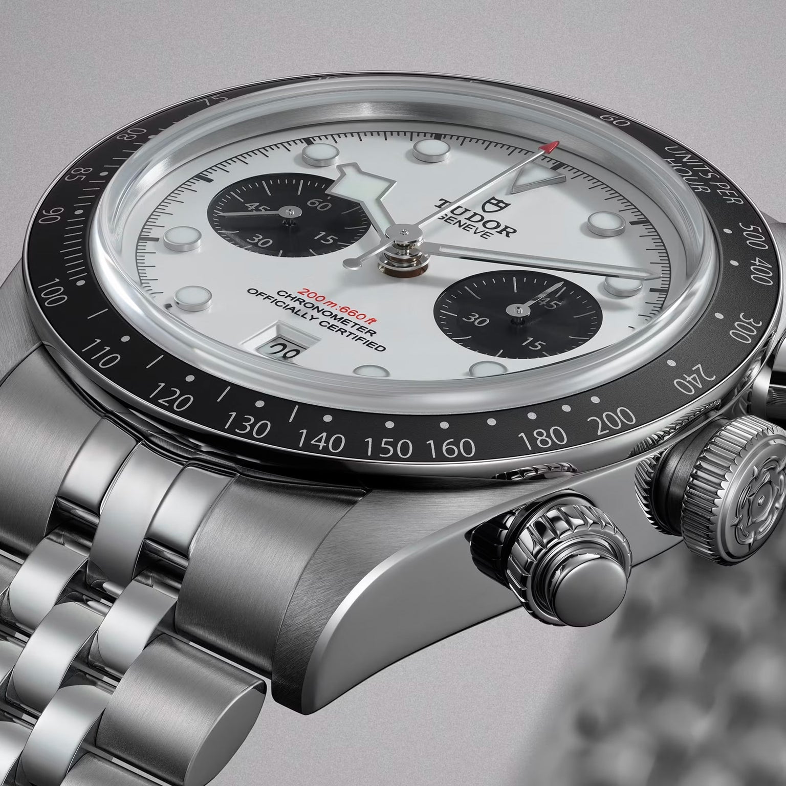 Close-up of a TUDOR Black Bay Chrono watch featuring a white dial, black bezel, and silver metal bracelet.