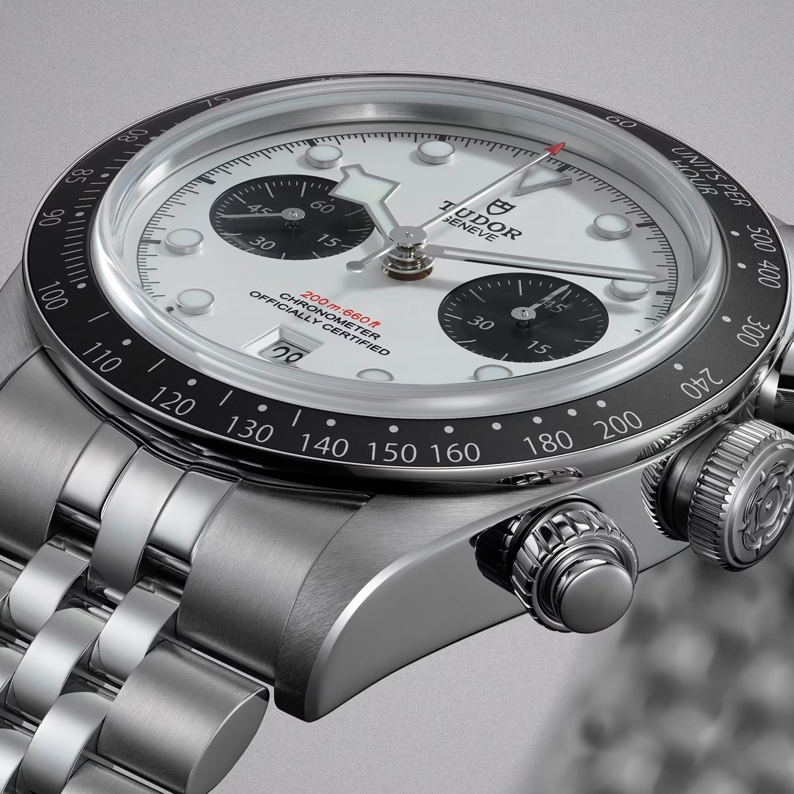 Close-up of a TUDOR Black Bay Chrono watch featuring a white dial, black bezel, and silver metal bracelet.