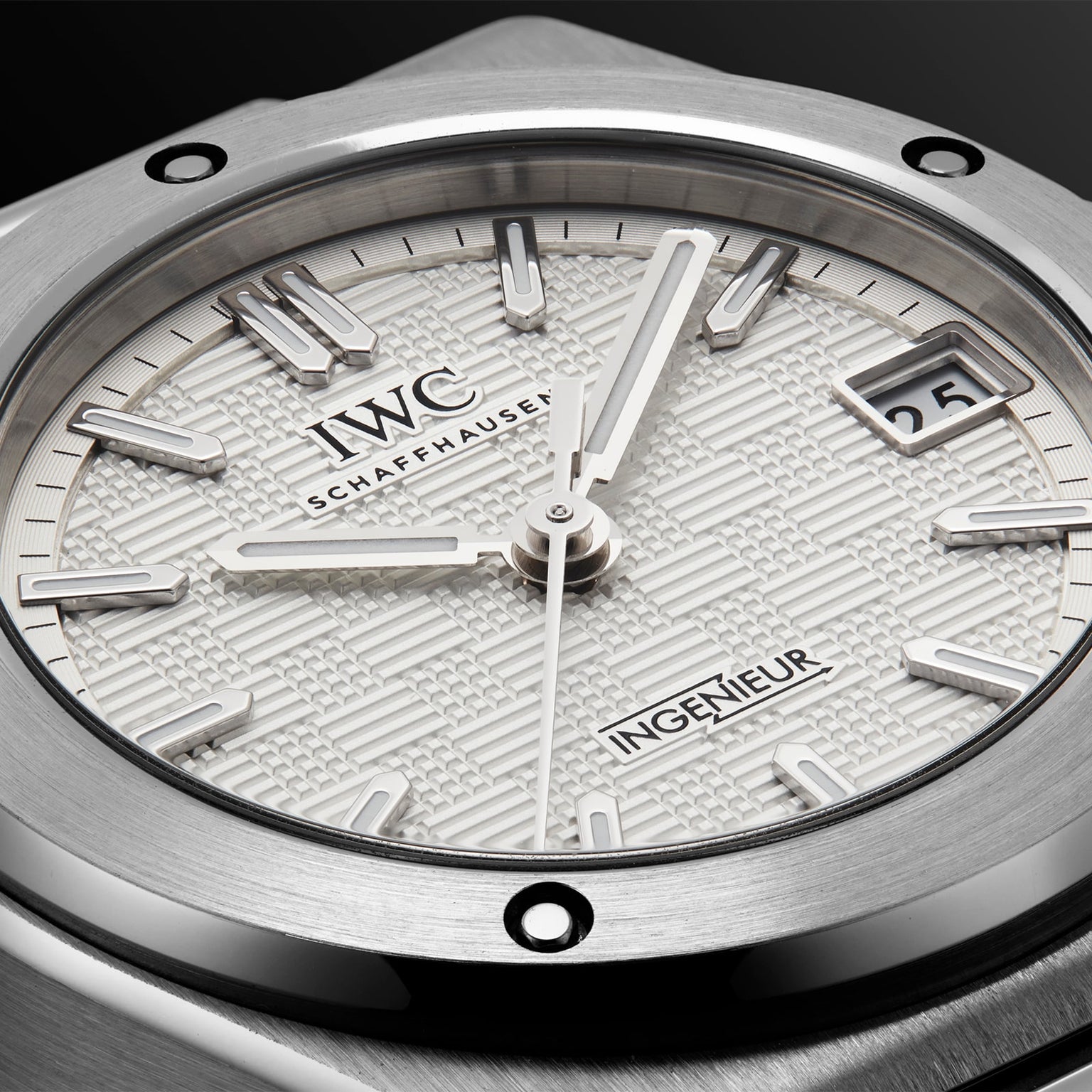 Close-up of the IWC Schaffhausen Ingenieur Automatic 35, featuring a textured white dial, silver markers and hands, plus a date window at 3 o’clock—an iconic timepiece inspired by Gérald Genta.