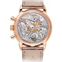 The Patek Philippe Complication 7150/250R-001 is a luxury watch featuring a rose gold case and a transparent back that reveals its intricate mechanical movement.