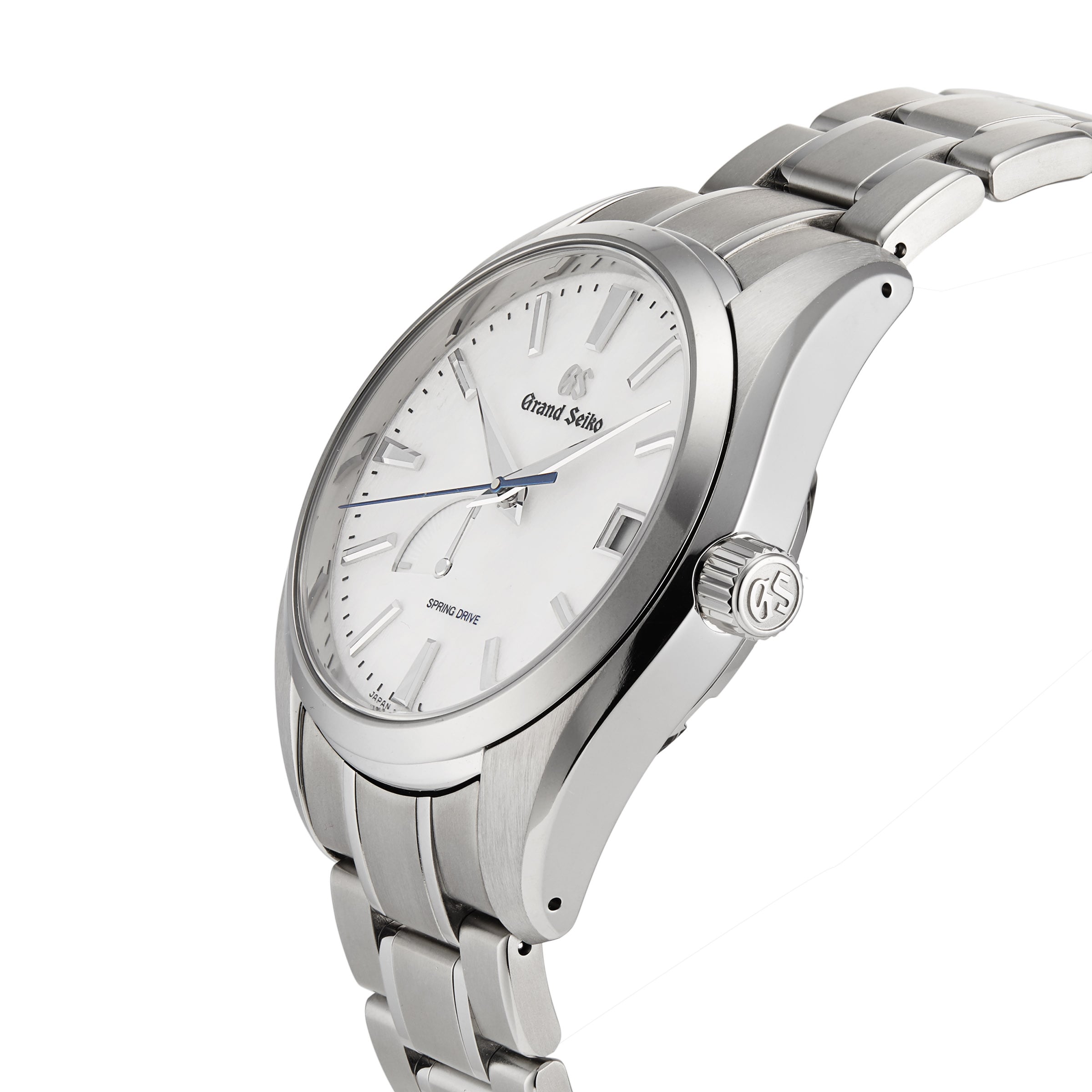 The Grand Seiko Spring Drive Heritage wristwatch features a white dial, silver hour markers, and a stainless steel bracelet, shown at an angle to highlight its precise Spring Drive movement.