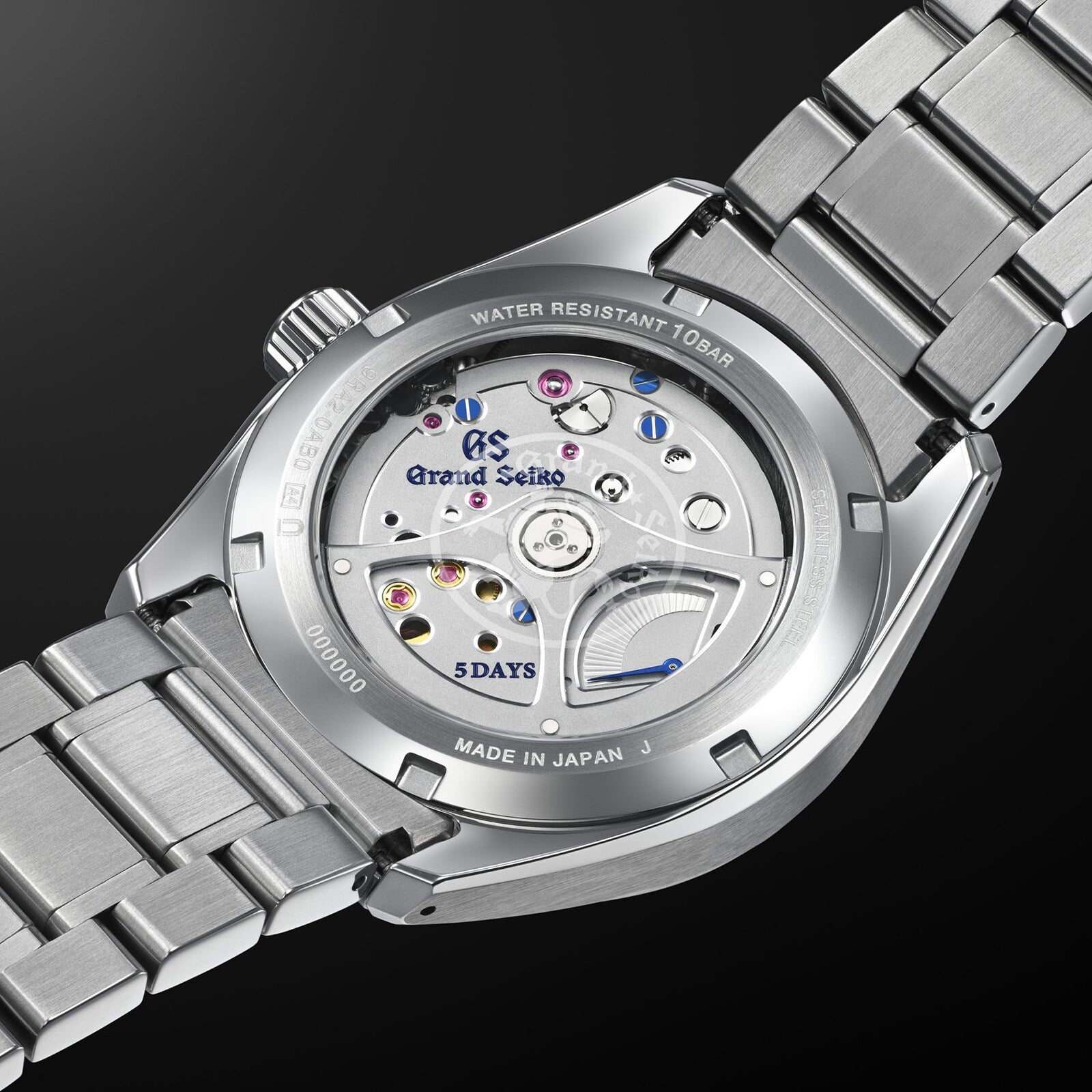 Close-up of the Grand Seiko Spring Drive 5 Days Evolution 9 wristwatch’s back, showcasing its Spring Drive movement through a transparent case with engraved branding and 5 DAYS power reserve—an elegant nod to Japanese craftsmanship.