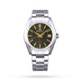 The Grand Seiko Hi-Beat Heritage is a stainless steel wristwatch with Zaratsu polishing, black dial, gold hour markers, date at 3 o’clock, and a metal bracelet—displayed against a plain white background.