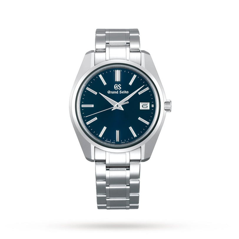 The Grand Seiko Quartz Heritage is a silver stainless steel wristwatch featuring a blue dial, Zaratsu-polished surfaces, silver hour markers, and a date display at 3 o’clock.