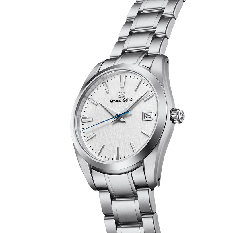 The Grand Seiko Quartz Heritage features a 37mm titanium case, snowflake dial, blue second hand, date window at 3 o’clock, and a stainless steel link bracelet.