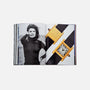 In Watches: A Guide By HODINKEE by Hodinkee, an open spread reveals a black and white portrait of a woman in a turtleneck beside two gold watches with black straps, echoing the brand’s curated style.