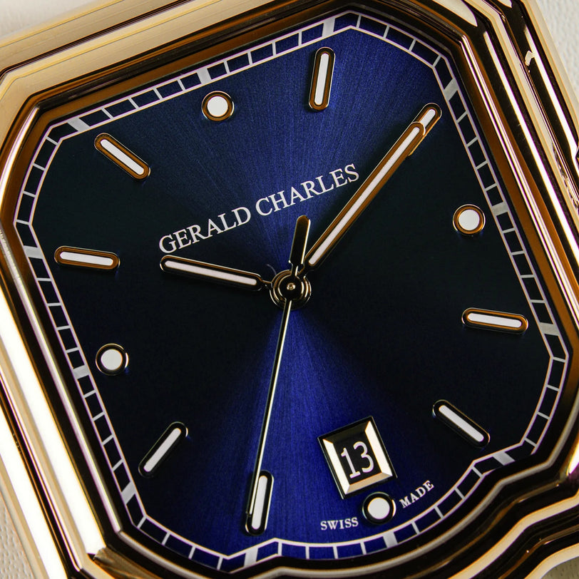 Close-up of the Gerald Charles Maestro 2.0 Ultra-Thin wristwatch with a royal blue sunburst dial, gold hour markers and hands, 18K Rose Gold 4N case, vulcanised rubber strap, and a date window displaying the number 13.