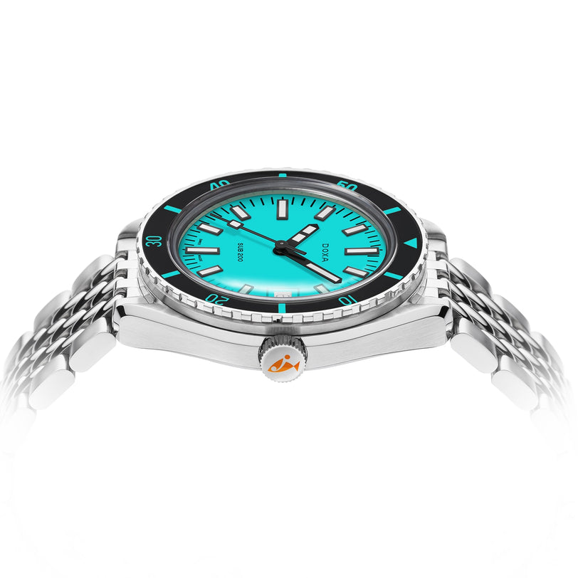 The DOXA Sub 200 Aquamarine is a silver diver’s watch with a turquoise dial, unidirectional rotating bezel, and orange crown detail, displayed at an angle on a 316L stainless steel bracelet.