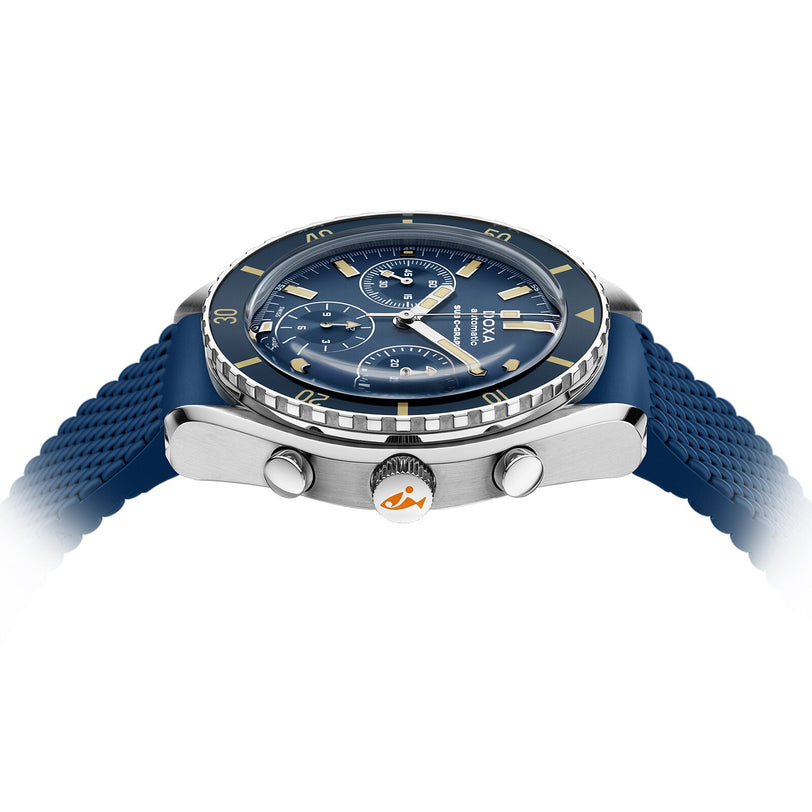 The DOXA Sub 200 C-Graph Caribbean divers watch features a blue rubber strap, three chronograph subdials, and a rotating bezel, displayed from the side on a white background.