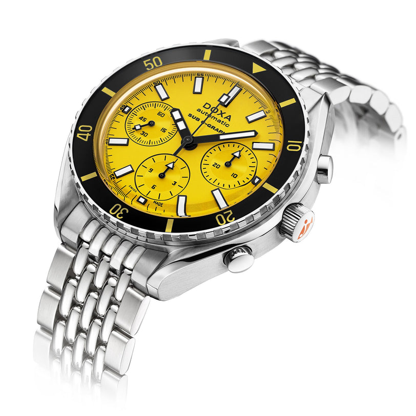 The DOXA Sub 200 C-Graph Divingstar, a stainless steel chronograph wristwatch with a yellow dial, black bezel, three subdials, and metal link bracelet, is displayed at an angle on a white background.