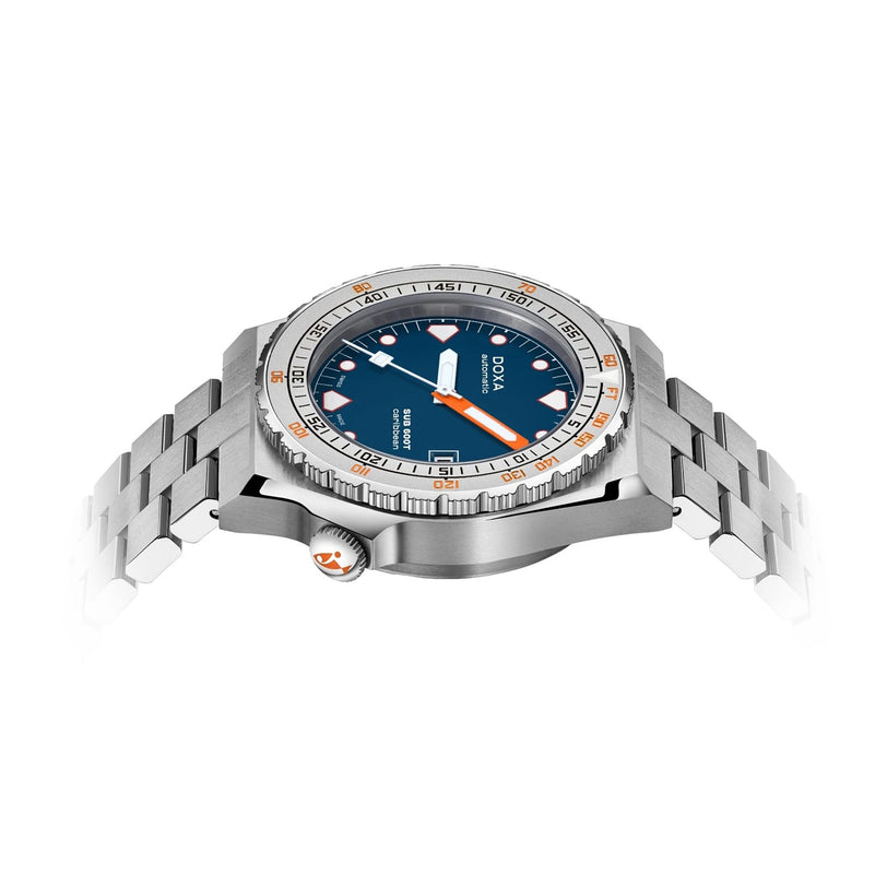 The DOXA Sub 600T Caribbean is a stainless steel dive watch featuring a blue dial with orange accents and a metal bracelet, viewed from a low angle on a white background—a bold addition to the DOXA collection.