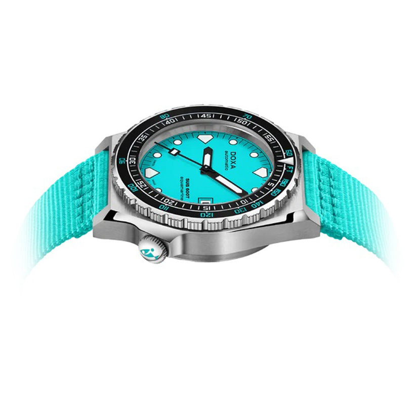 The DOXA Sub 600T Aquamarine is a silver-tone 316L stainless steel diver’s watch with an aquamarine dial, matching fabric strap, black rotating bezel, and bold hour markers, shown against a white background.