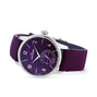 The Louis Erard Petite Seconde Violette features a purple dial, silver case, white hour markers, and a purple leather strap, displayed on a white background.