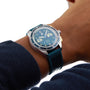 A person wearing the William Wood Triumph Collection - Oxygen Edition wristwatch, featuring a blue face and blue strap, on their left wrist.