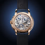 Close-up of Arnold & Son Perpetual Moon 41.5mm Red Gold’s intricate exposed movement, gold casing, and black leather strap.