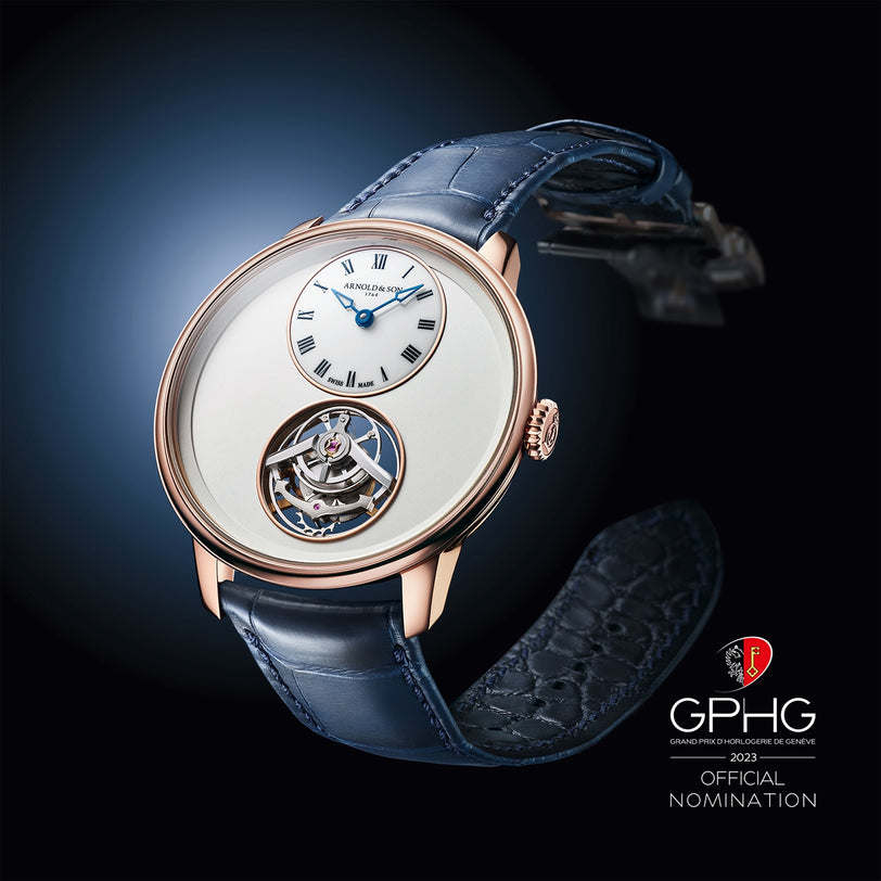 The Arnold & Son Ultrathin Tourbillon Red Gold is a luxury wristwatch featuring a blue strap, open tourbillon, and the GPHG 2023 official nomination badge.