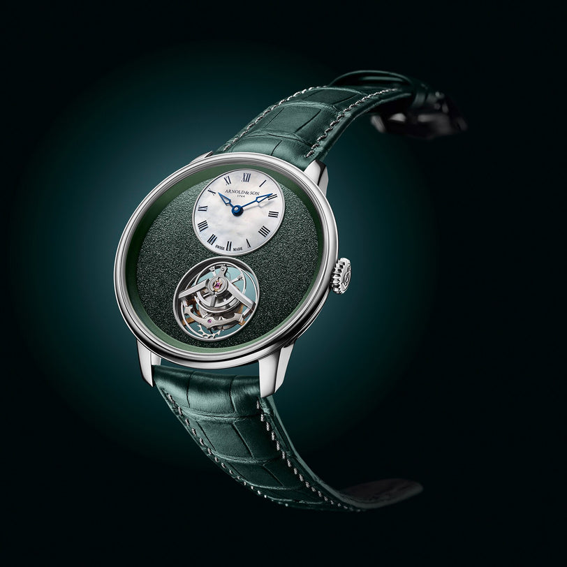 The Arnold & Son Ultrathin Tourbillon Platinum is a luxury green watch featuring a small white dial, visible tourbillon, and matching green leather strap.