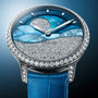 The Arnold & Son Perpetual Moon 38 White Gold Mintnight features a diamond bezel, blue strap, and a dial with a starry night sky design accented with sparkling details.