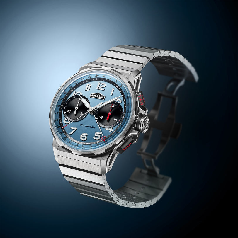 Angelus Chronodate Titanium Storm Blue Titanium wristwatch with a blue face, two black subdials, and a metal strap, shown on a blue gradient background.