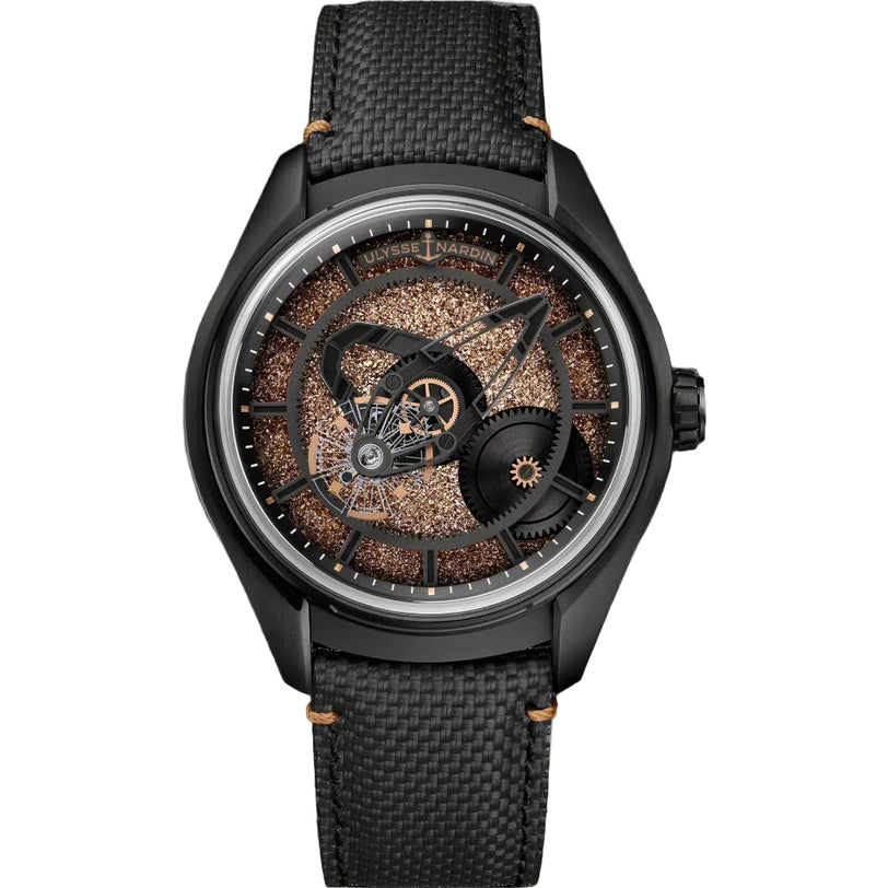 The Ulysse Nardin Freak X Crystalium is a luxury wristwatch with a black textured strap and an intricate skeletonized face, showcasing bronze and black gears beneath a transparent Crystalium dial, with bronze-accented hands and indices for exclusivity.